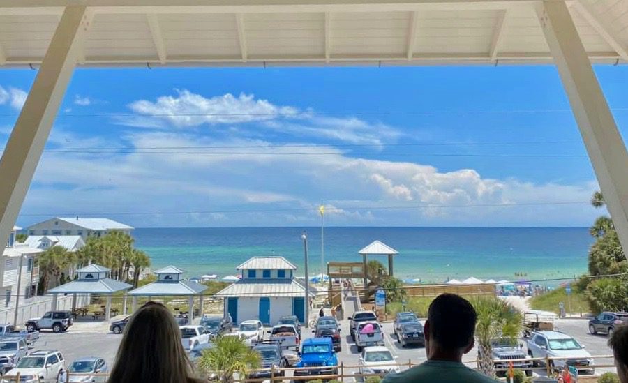 Crowd enjoying drinks and music with an ocean view at Shunk Gulley Oyster Bar